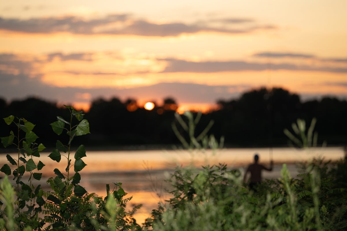 Fischer am Fluss bei Sonnenuntergang