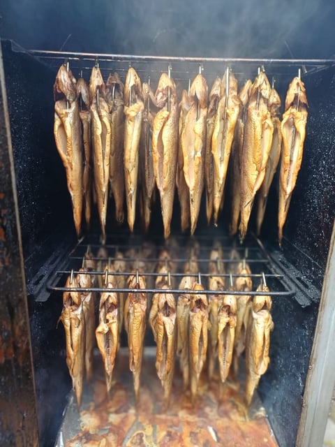 Mehrere Reihen geräucherter Forellen am Haken